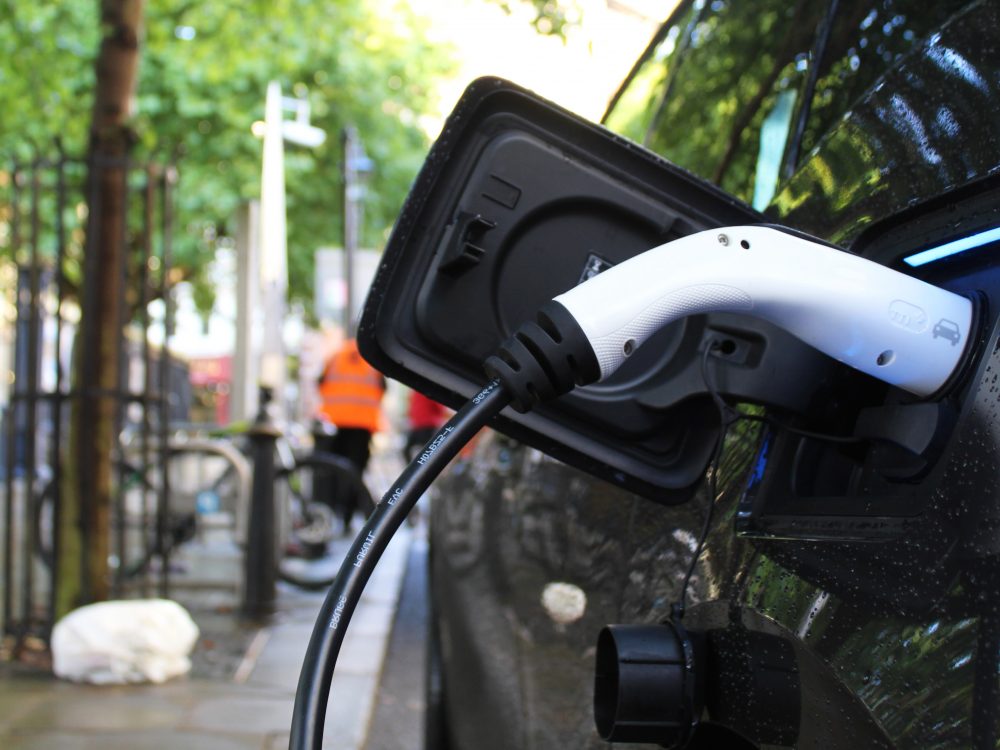 A couple looking through a hide and holding binoculars at RSPB Titchwell Marsh Nature Reserve in West Norfolk.