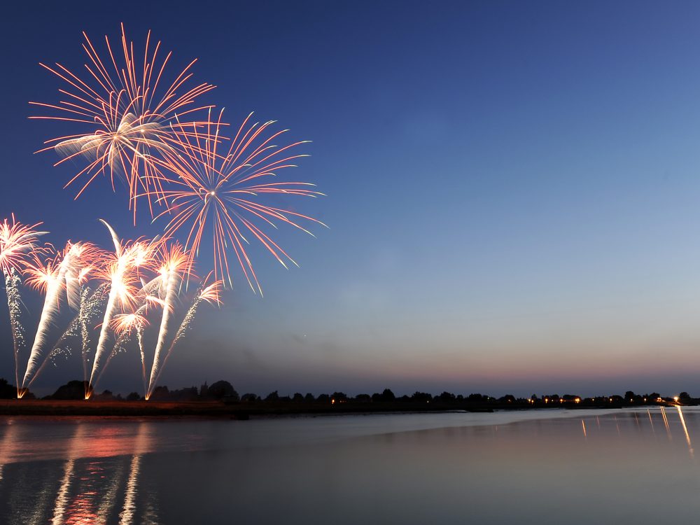 Fireworks in the night sky reflecting onto the water. The shot was taken from South Quay in King's Lynn.