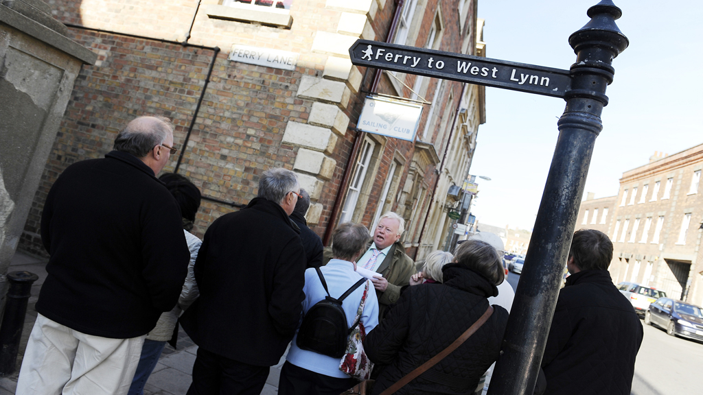 A shot of a town guide talking to a group of visitors down King Street in King's Lynn.
