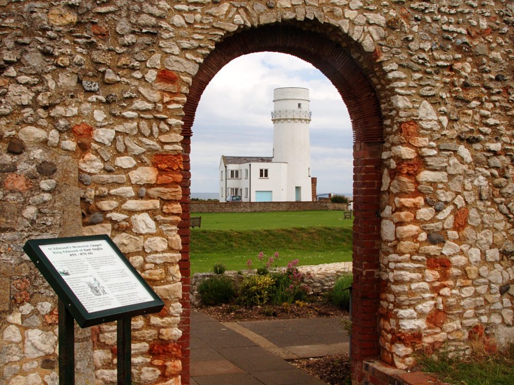 Two children jumping from rocks at Old Hunstanton beach. The girl is wearing a top that says 
