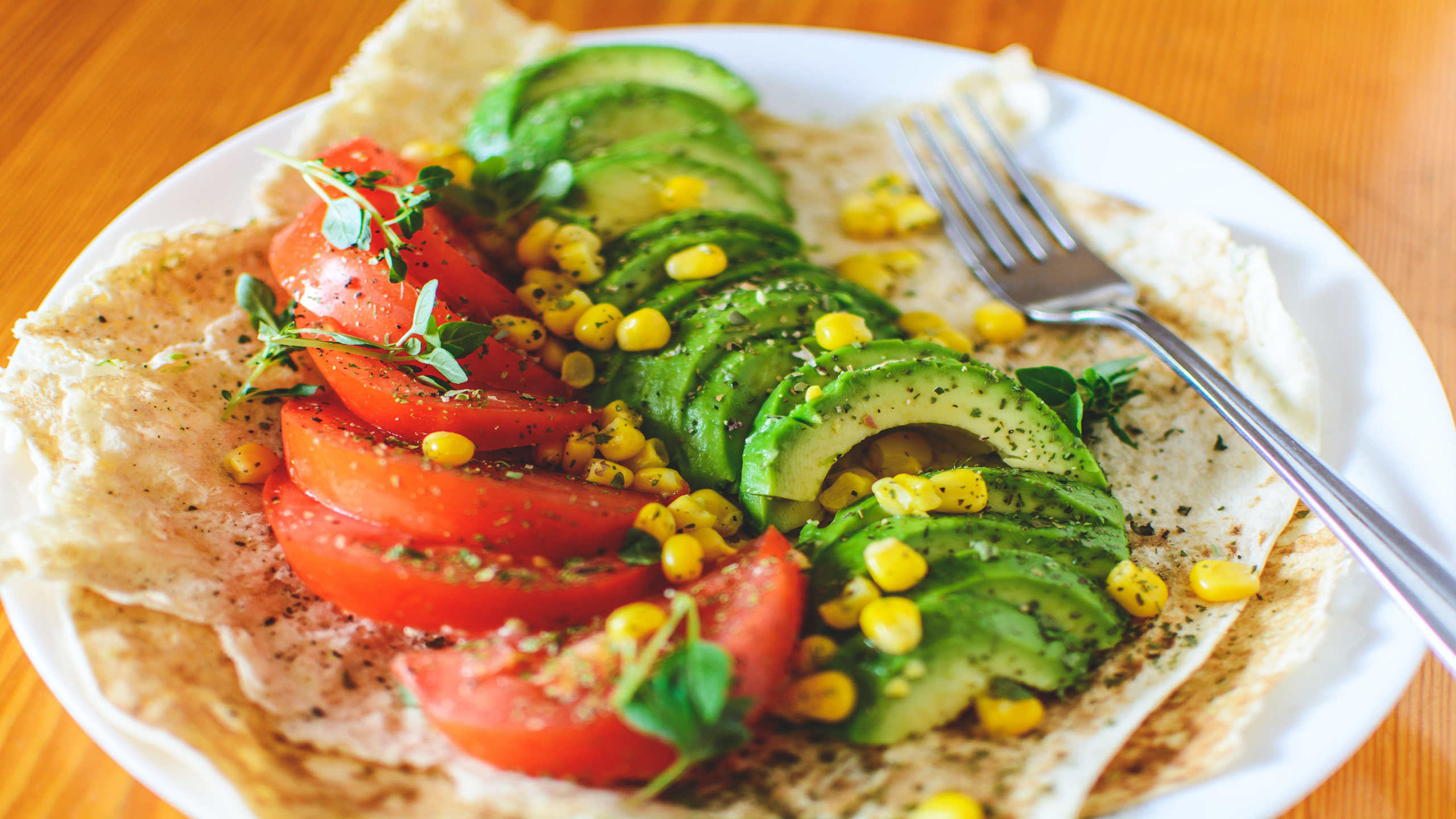 A vegan and vegetarian dish of tomatoes, avocado and sweetcorn.