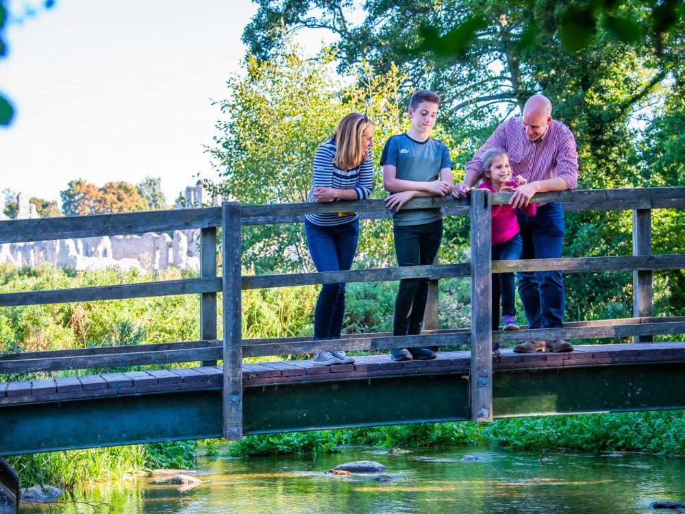 A couple looking through a hide and holding binoculars at RSPB Titchwell Marsh Nature Reserve in West Norfolk.