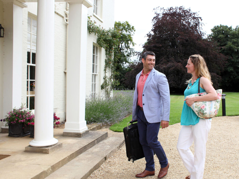 A couple looking through a hide and holding binoculars at RSPB Titchwell Marsh Nature Reserve in West Norfolk.