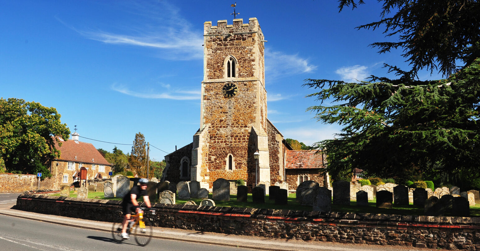 A cyclist biking through a west Norfolk village