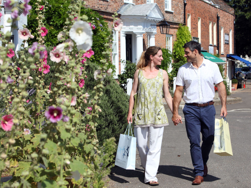A couple looking through a hide and holding binoculars at RSPB Titchwell Marsh Nature Reserve in West Norfolk.