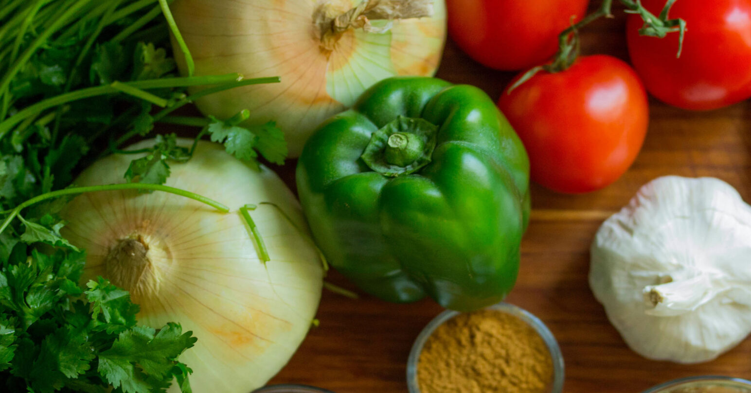 Seasonal vegetables including onion, pepper, tomato and garlic