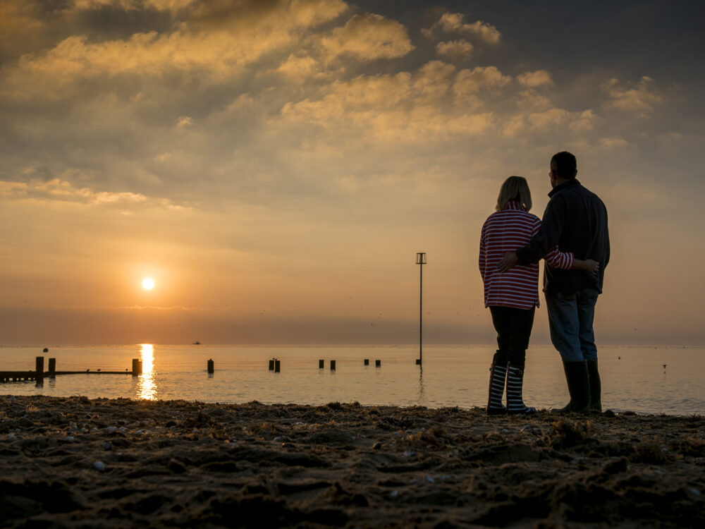 A couple watching the sunset at Hunstanton Beach in West Norfolk
