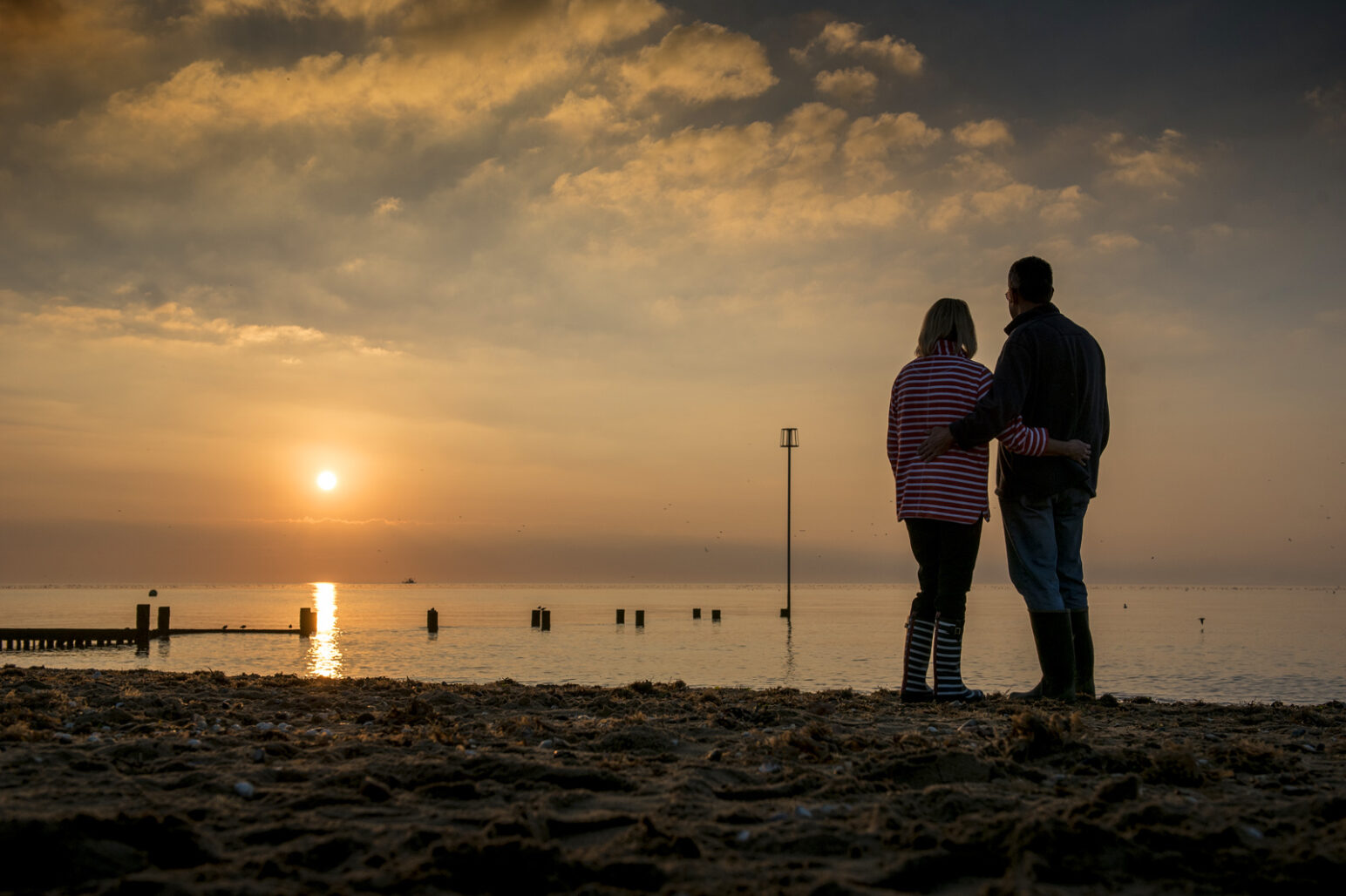 A couple watching the sunset at Hunstanton Beach in West Norfolk