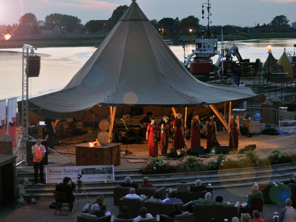 Performers singing underneath a tent in South Quay, King's Lynn.