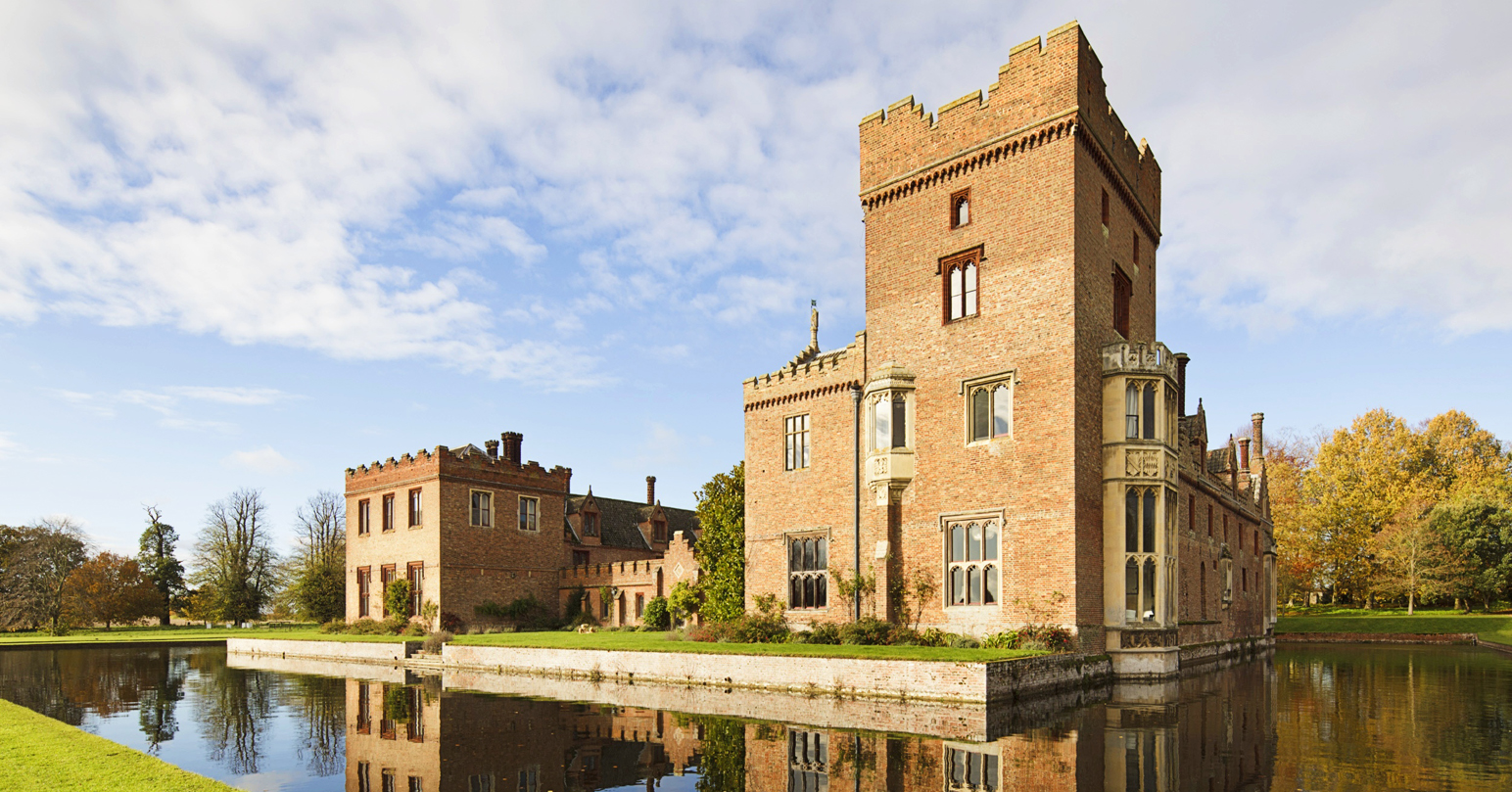 The exterior of Oxburgh Hall standing within a square moat.