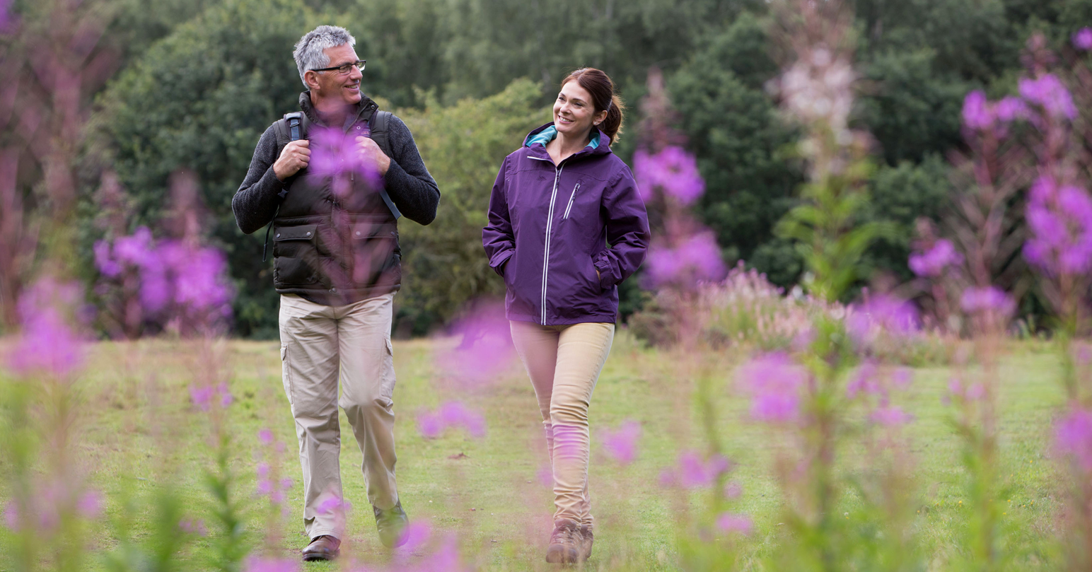A couple walking through the grounds of Castle Acre Priory in West Norfolk.