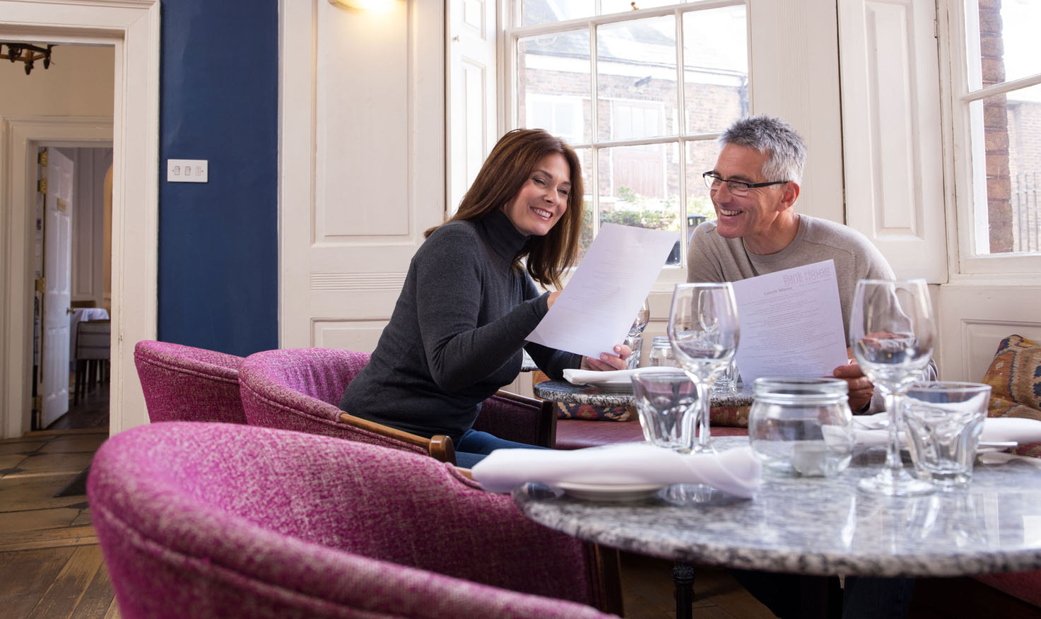 A couple looking at a menu inside a West Norfolk restaurant.