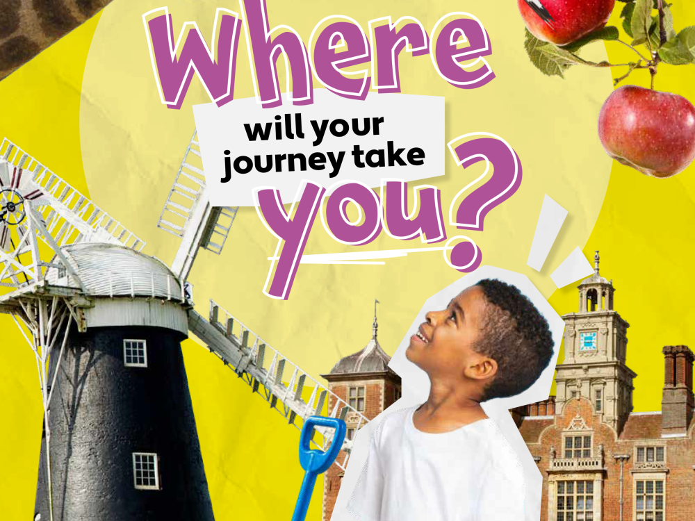 A couple looking through a hide and holding binoculars at RSPB Titchwell Marsh Nature Reserve in West Norfolk.