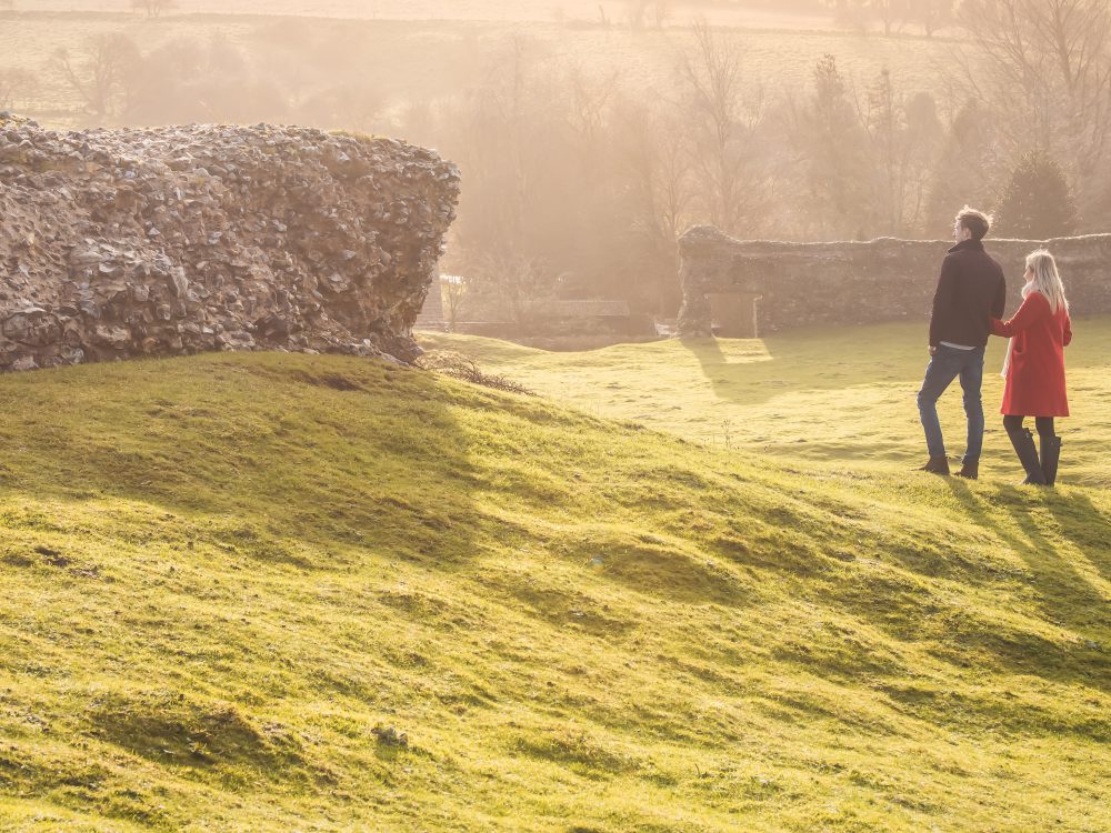 A couple overlooking the ruins of Castle Acre Castle in West Norfolk.