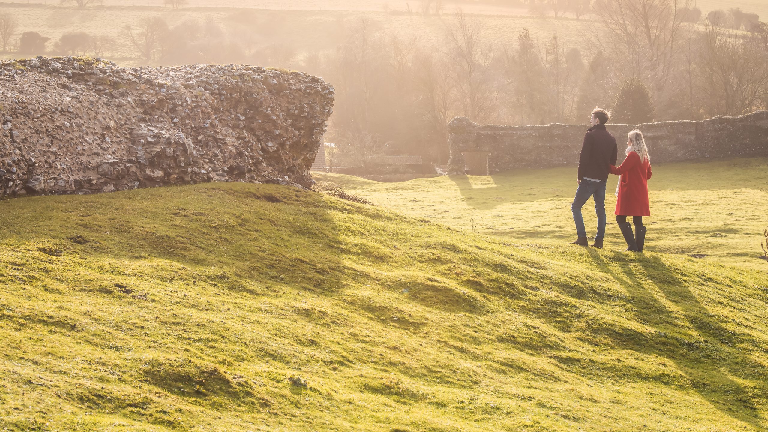 A couple overlooking the ruins of Castle Acre Castle in West Norfolk.