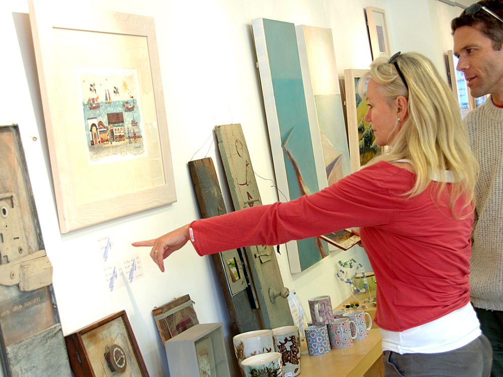 A couple pointing at artwork inside a gift shop in west Norfolk.