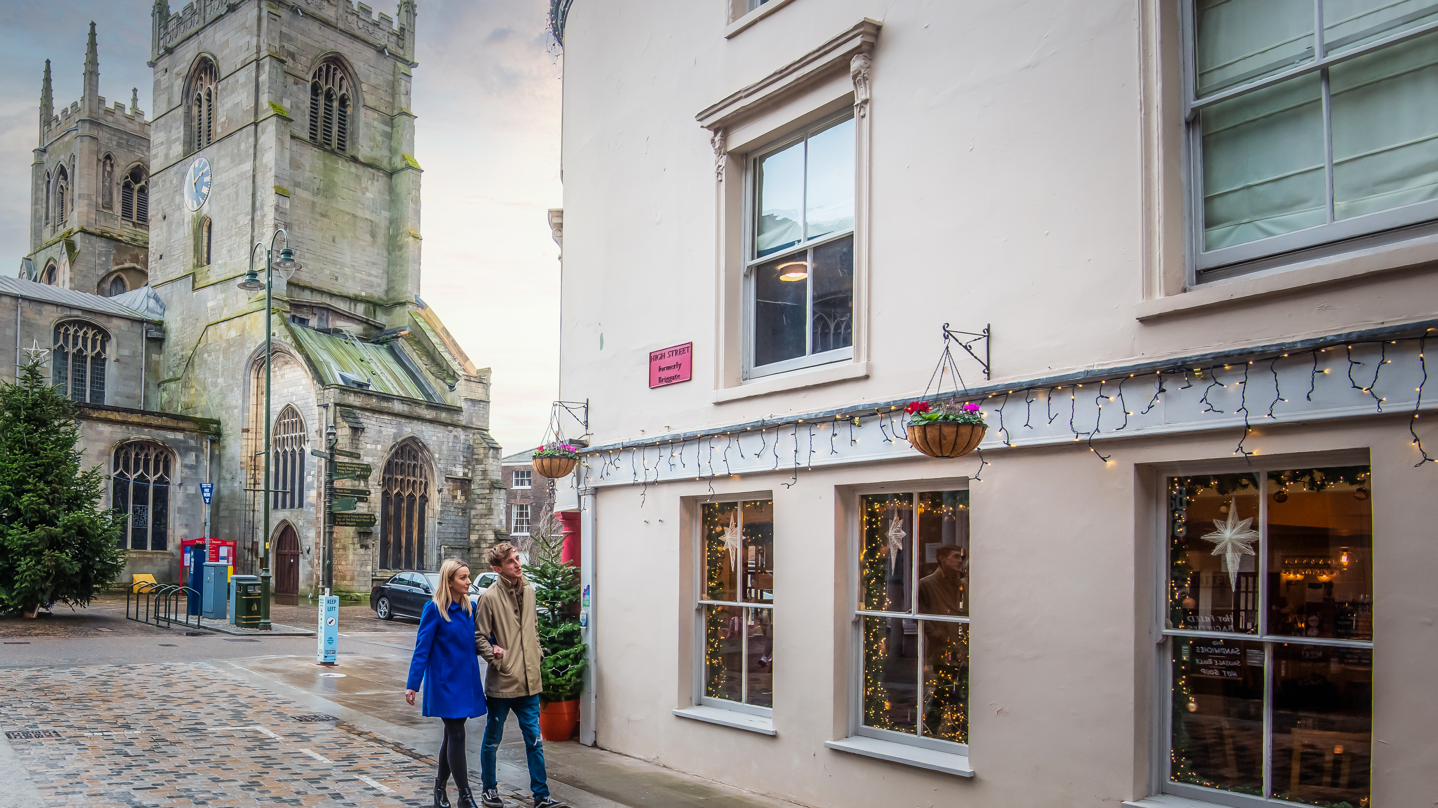 A couple walking past a restaurant decorated with Christmas Lights on the Saturday Market Place in King's Lynn, West Norfolk.